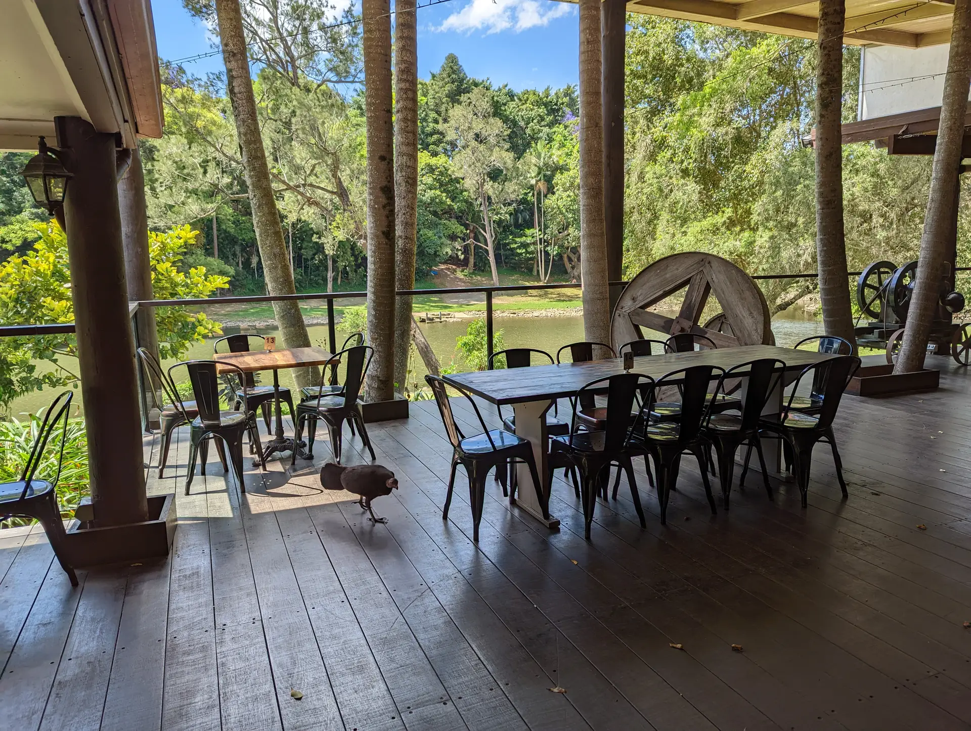 A group dining on the deck overlooking the Coomera River at Historic Rivermill