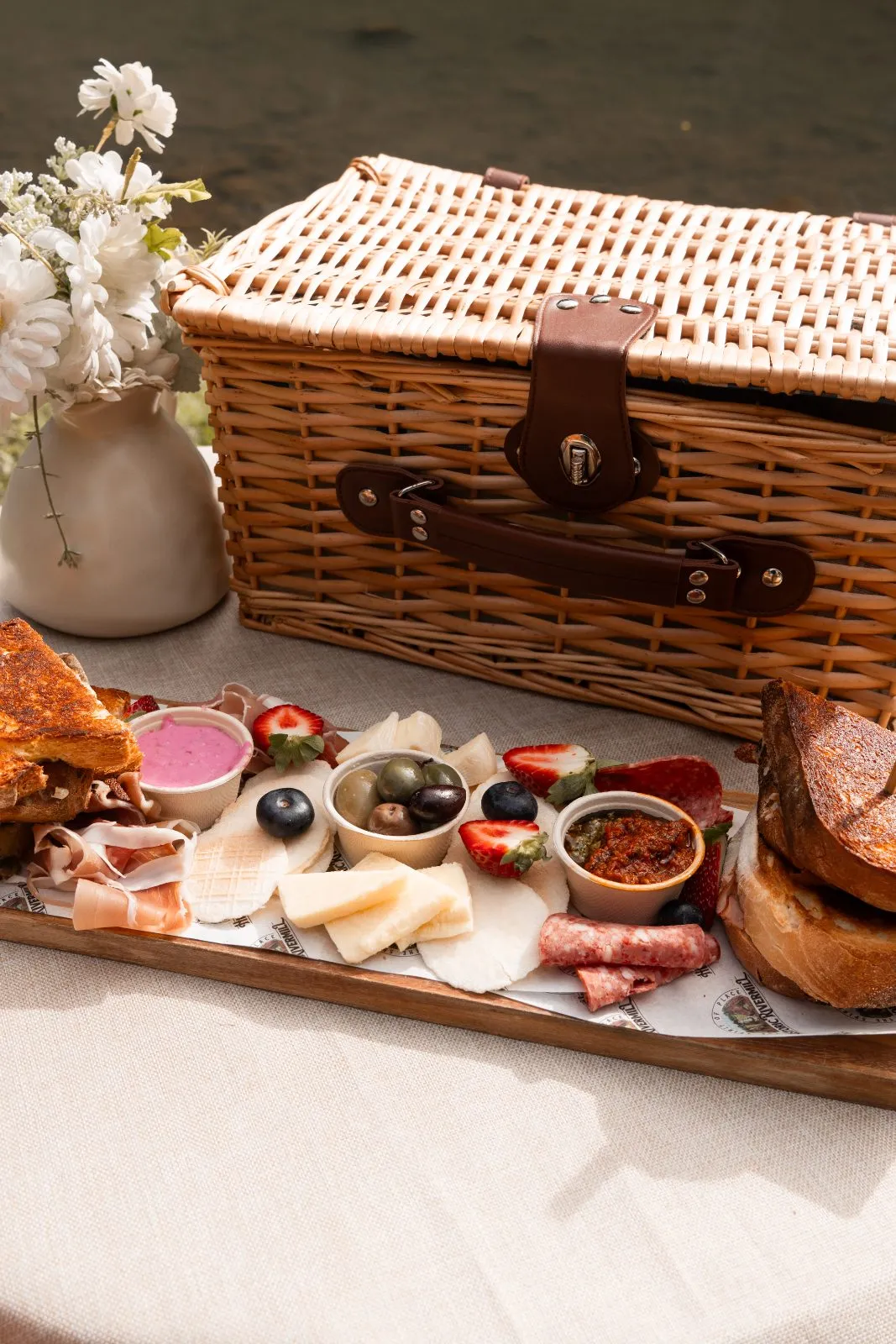 The Rivermill picnic hamper with a grazing board of cheeses, prosciutto, salami, olives, strawberries and toasted sourdough